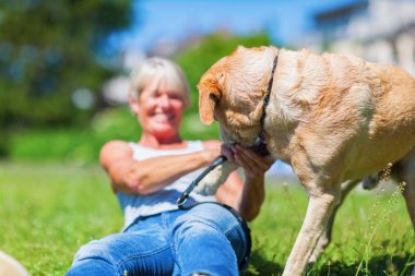 Olgun kadın açık havada köpeğiyle oynuyor