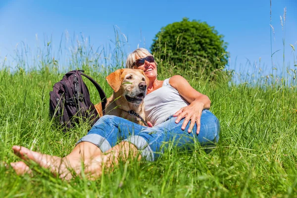 Mulher madura com cão em um descanso caminhadas — Fotografia de Stock