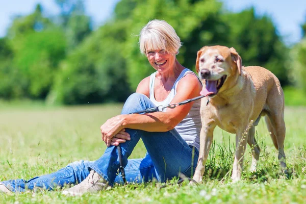 Mulher madura com um cão ao ar livre — Fotografia de Stock