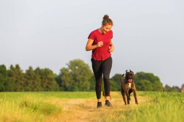 genç kız ile bir boxer köpek jogs