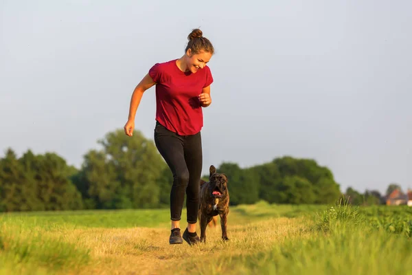 Young girl jogs with a boxer dog — Stock Photo, Image
