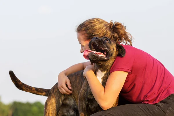 Joven chica abraza su boxeador perro — Foto de Stock