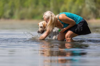 Olgun kadın gölde bir labrador çalış