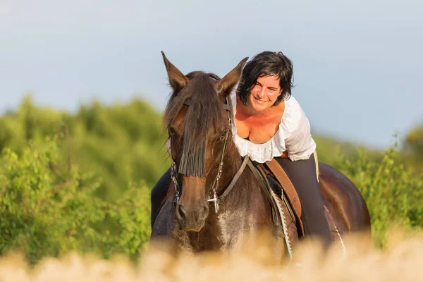 Portrait of a mature woman on an Andalusian horse — Stock Photo, Image