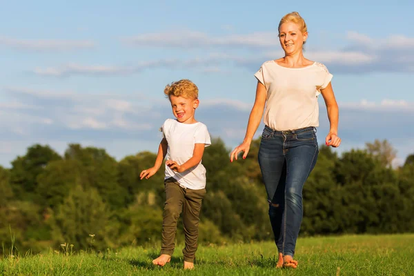 Anne oğlu ile çayır üzerinde çalışır.