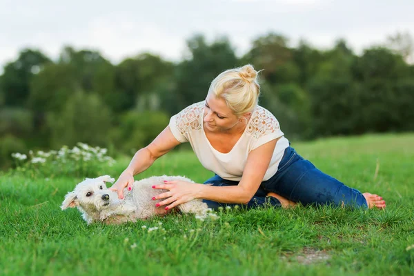 Mulher joga com um terrier híbrido ao ar livre — Fotografia de Stock