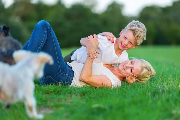 kadın oğluyla birlikte çimlere gebertiyor.