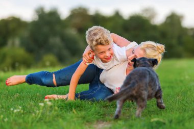 Kadın oğlunu ve bir köpek çimlere gebertiyor