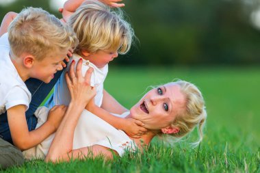 kadın onun iki oğlu ile çimlere gebertiyor.