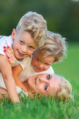 kadın onun iki oğlu ile çimlere gebertiyor.