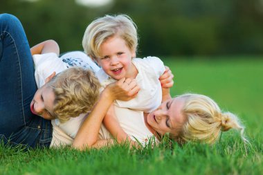kadın onun iki oğlu ile çimlere gebertiyor.
