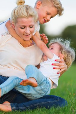 kadın onun iki oğlu ile çimlere gebertiyor.