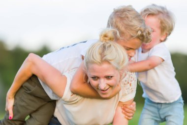 kadın onun iki oğlu ile çimlere gebertiyor.