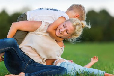 kadın onun iki oğlu ile çimlere gebertiyor.