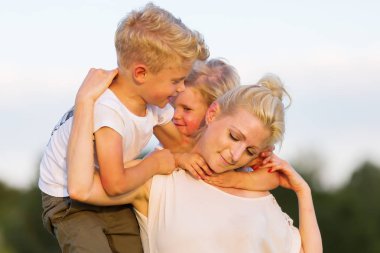 kadın onun iki oğlu ile çimlere gebertiyor.