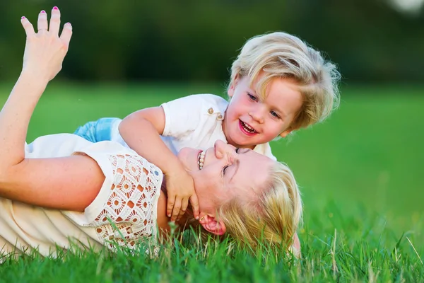 kadın oğluyla birlikte çimlere gebertiyor.