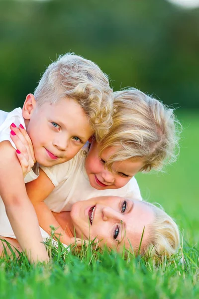 kadın onun iki oğlu ile çimlere gebertiyor.