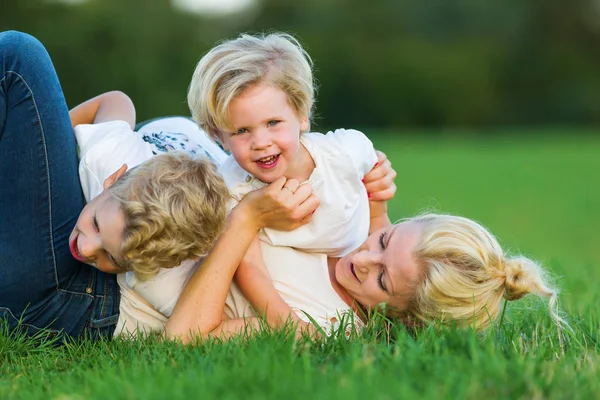 kadın onun iki oğlu ile çimlere gebertiyor.