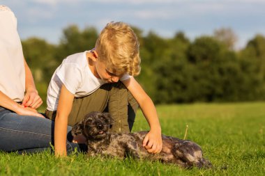 Anne ile oğlu küçük bir köpekle oynamayı