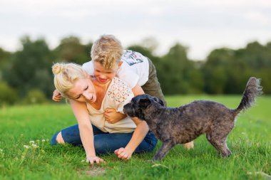 Kadın oğlunu ve bir köpek çimlere gebertiyor