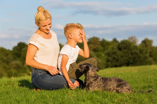Anne ile oğlu küçük bir köpekle oynamayı