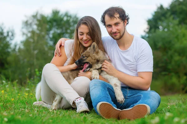 Retrato de um jovem casal com um cachorro elo — Fotografia de Stock