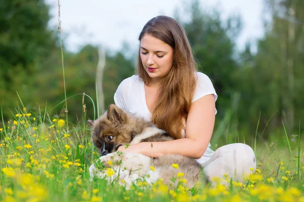 genç kadın bir Elo köpek çim ile oturur