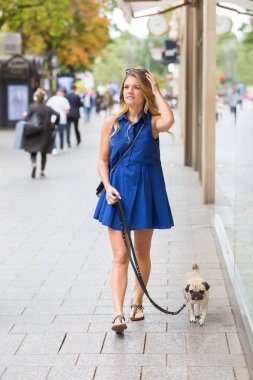 hem de bir dükkan pencere boyunca ile genç kadın yürüyor