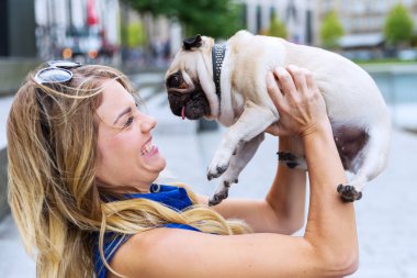 onun sevimli pug kadar genç kadın yükseltir