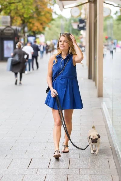 hem de bir dükkan pencere boyunca ile genç kadın yürüyor