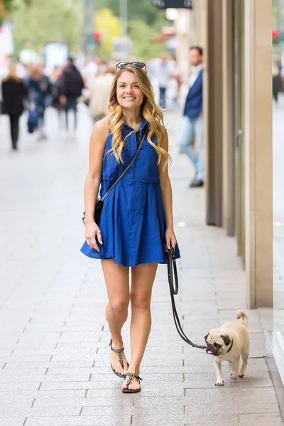 hem de bir dükkan pencere boyunca ile genç kadın yürüyor