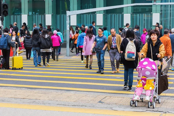 Menschenmassen überqueren eine Straße in Hongkong — Stockfoto