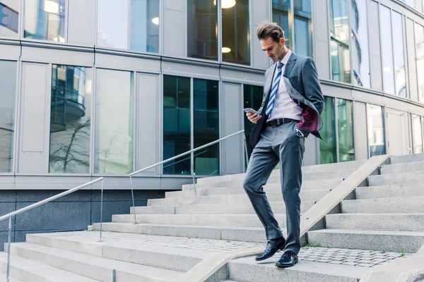 Businessman walking downstairs in an office park — Stock Photo, Image