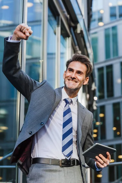 işadamı bir ofis kazanan poz binası önünde duruyor