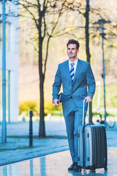 Hombre de negocios camina con una bolsa de carrito en la ciudad —  Fotos de Stock