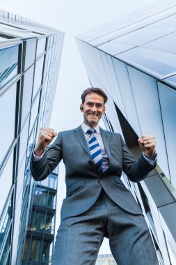 işadamı gökdelenler arasında duruyor ve bir kazanan yapar yumruk