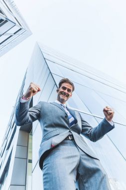 işadamı gökdelenler arasında duruyor ve bir kazanan yapar yumruk