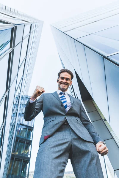 işadamı gökdelenler arasında duruyor ve bir kazanan yapar yumruk