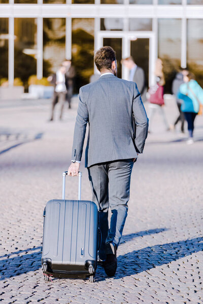 rear view of a businessman with a trolley bag