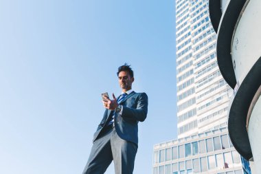 bir cep telefonu ile ilgilenen bir işadamı portresi