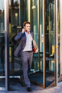 işadamı kulaklık ile bir ofis binası dışında gelir