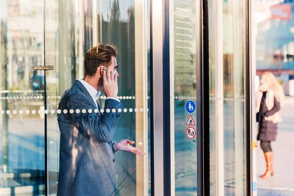 işadamı kulaklık ile bir ofis binası dışında gelir