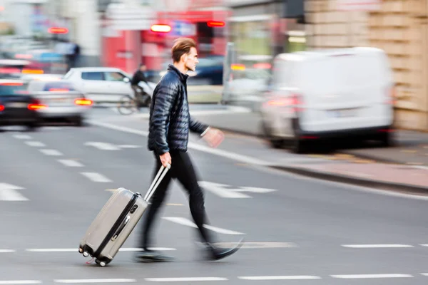 Homem de negócios com saco de carrinho atravessa a rua — Fotografia de Stock