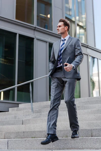 Businessman walking downstairs in an office park — Stock Photo, Image