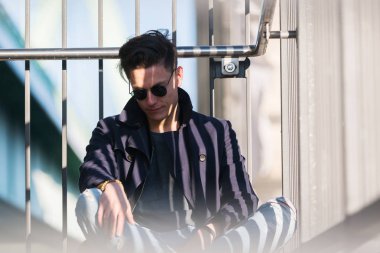 genç adam bir parmaklık oturur