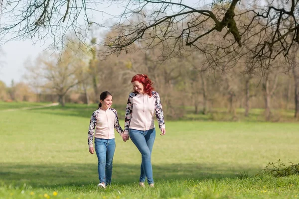 Madre e hija caminando en un parque — Foto de Stock