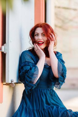 Kızıl saçlı kadın şaşırmış görünüyor