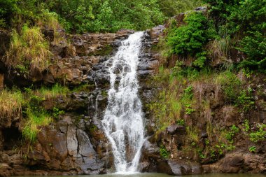 Haleiwa, Oahu, Hawaii, ABD - Kasım 06, 2019: Waimea Vadisi botanik bahçesinde kimliği belirsiz insanlarla birlikte şelale. Waimea Vadisi botanik bahçesinin de bulunduğu tarihi bir doğa parkı.