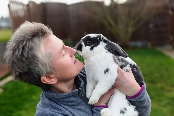 Reife Frau Hält Ein Kaninchen Den Armen — Stockfoto