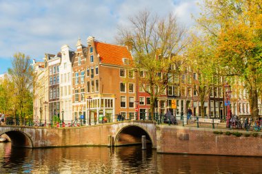 Amsterdam, Hollanda - 28 Ekim 2019: Amsterdam 'da kimliği belirsiz insanların bulunduğu tipik kanal manzarası. Amsterdam, Hollanda 'nın başkenti ve en kalabalık şehridir.